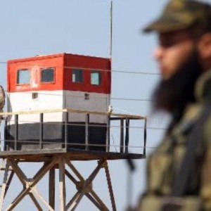 معبر رفح ويبدو رجل امن فلسطيني يقابله برج مراقبة مصري 