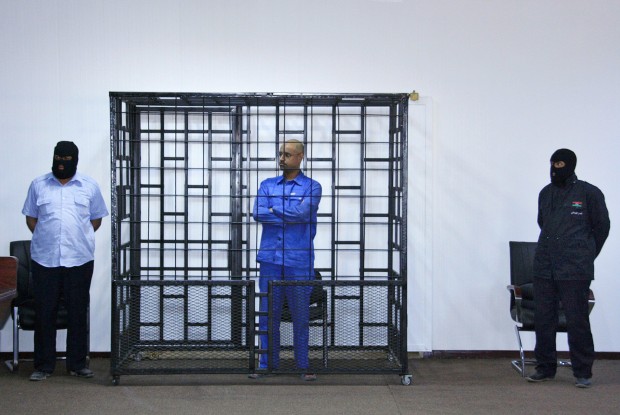 Saif al-Islam Gaddafi attends a hearing behind bars in a courtroom in Zintan