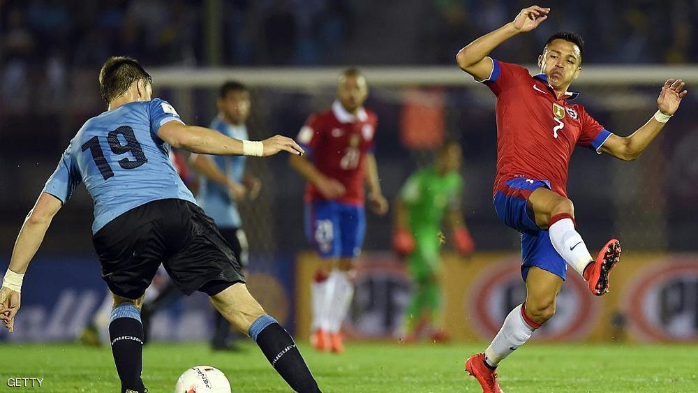 لاعب أوروغواي سيباستيان كواتس يحاول الاحتفاظ بكرة أمام سانشز في مباراة الثلاثاء