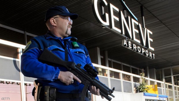 أحد أفراد الشرطة يقوم بدورية حراسة خارج مطار جنيف - 12 ديسمبر 2015.
