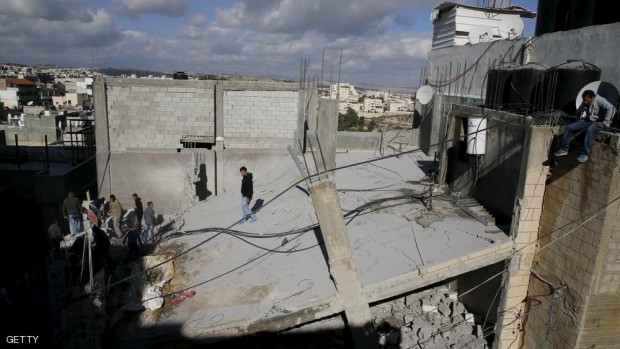 شبان فلسطينيون يعتلون منزل إبراهيم العكاري الذي دمرته إسرائيل