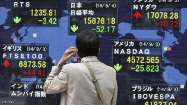 أحد المارة يتابع حركة المؤشرات عبر لوحة إلكترونية خارج بورصة طوكيو (أرشيفية)