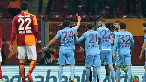 اللاعب التركي يشهر البطاقة الحمراء بوجه الحكم