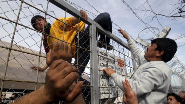 مهاجر عند سياج حدودي على الحدود اليونانية مع مقدونيا