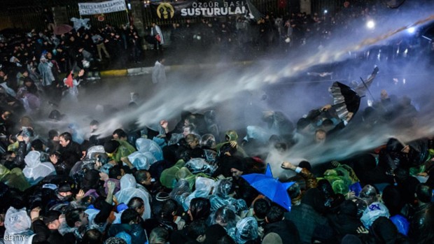 الشرطة تستخدم خراطيم المياه لقمع المحتجين أمام مقر الصحيفة.