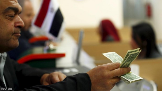A customer checks his U.S. dollar money in a bank in Cairo