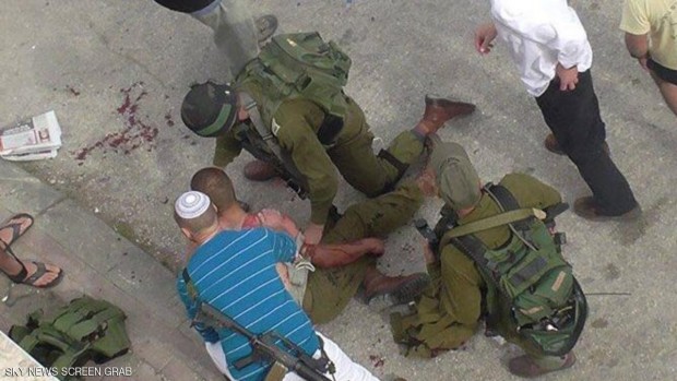 جنود إسرائيليون ومستوطنون يسعفون جنديا أصيب في عملية الطعن بالخليل الخميس
