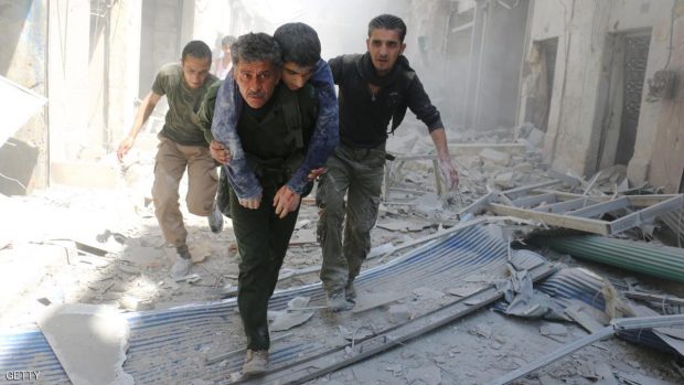 Syrians evacuate an injured man amid the rubble of destroyed buildings following a reported air strike on the rebel-held neighbourhood of Al-Qatarji, in the northern Syrian city of Aleppo, on April 29, 2016. Fresh bombardment shook Syria's second city Aleppo, severely damaging a local clinic as outrage grows over an earlier air strike that destroyed a hospital. The northern city has been battered by a week of air strikes, rocket fire, and shelling, leaving more than 200 civilians dead across the metropolis. The renewed violence has all but collapsed a fragile ceasefire deal that had brought an unprecedented lull in fighting since February 27. / AFP / AMEER ALHALBI (Photo credit should read AMEER ALHALBI/AFP/Getty Images)