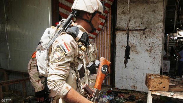 رجل أمن عراقي يتفحص أحد مواقع التفجيرات