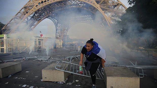 Tear gas floats in the air near the Eiffel Tower outside the Paris fan zone during clashes before a EURO 2016 final soccer match