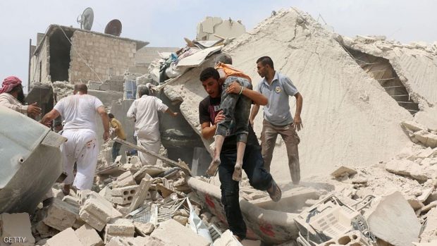 رجل يحمل طفلا مصابا عقب غارة جوية على حي باب النيرب بحلب